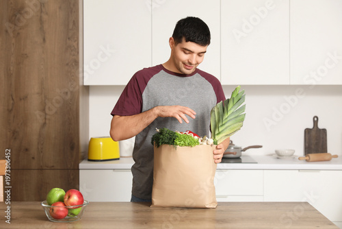 Young man with grocery bag ...