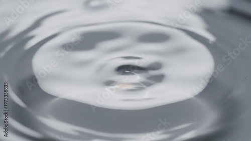 Close-up of a drop of liquid metal, mercury, reflecting its shape on a surface