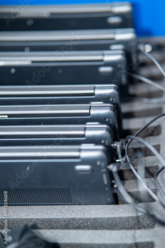 Close-up of stacked laptop computers stored in a row