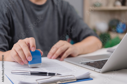 Canvas-taulu Close up hand of startup founder stamping business report with laptop on table