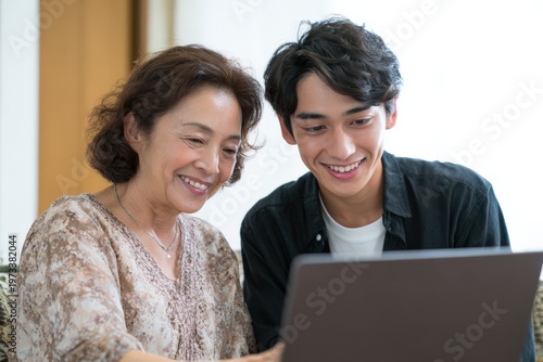 ノートパソコンを見る祖母と孫