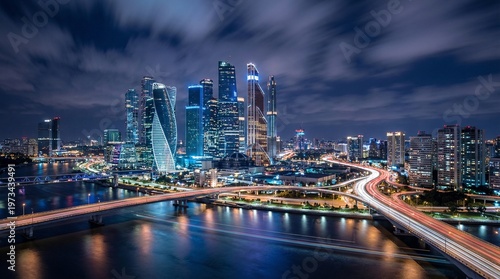 Obraz na plátne A cityscape at night with a bridge and skyscrapers lit up