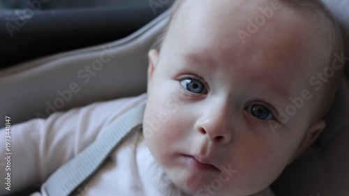 Adorable Infant Calmly Watches While Being Comforted Indoors. Candid Portrait Of Baby Attentively Inspecting Surroundings With Peaceful Expression And Tender Closeness