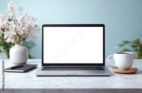 Laptop with blank screen on white marble table and coffee cup.