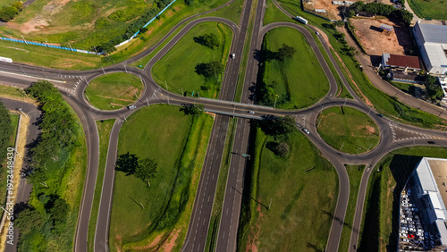 An aerial view of a complex highway interchange with multiple roundabouts and green spaces