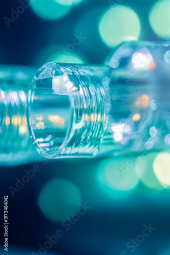 A clear glass bottle sits on a table with a wooden or stone surface, awaiting use or decoration vertical frame