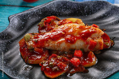 Canvastavla Baked fish fillet with tomato sauce and vegetables on a rustic blue wooden table