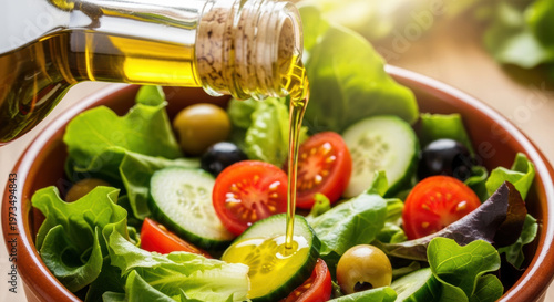 Fresh salad with olive oil being poured, healthy eating concept