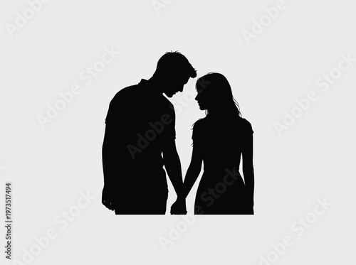 A black silhouette of a romantic young couple standing together while holding hands intimately.