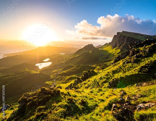 Dramatic landscape vista featuring verdant hills, a rocky ridge, and small lakes reflecting the warm light of the setting sun