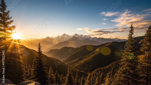 Golden light over vast mountain range and evergreen forest at dawn