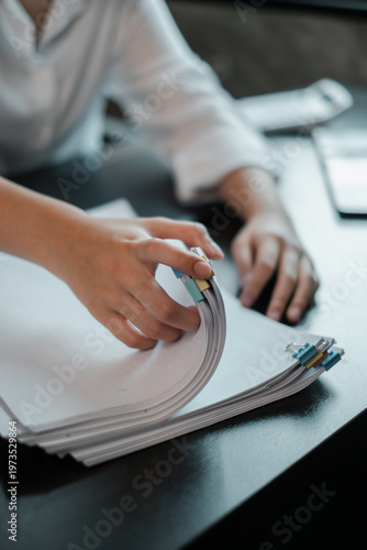 Close-up of hands sorting papers on a desk, symbolizing organization and productivity in a professional office setting.
