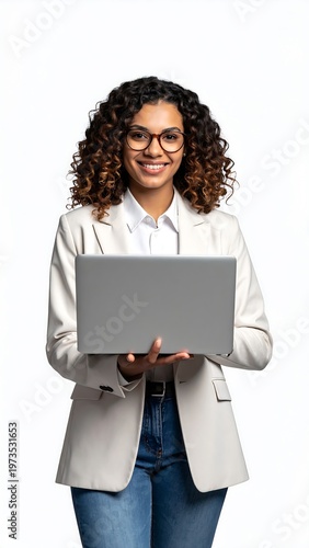 A smiling, professional woman with curly hair, wearing glasses and a blazer, holds a laptop. The background is white