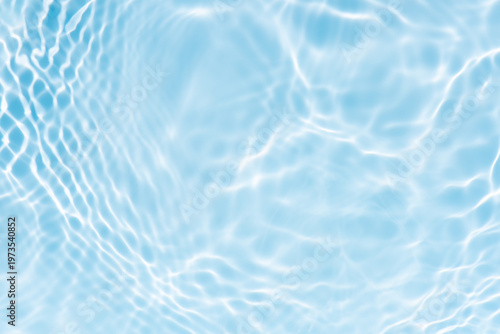 Blue water with ripples on the surface. Defocus blurred transparent blue colored clear calm water surface texture with splashes and bubbles. Water waves with shining pattern texture background.