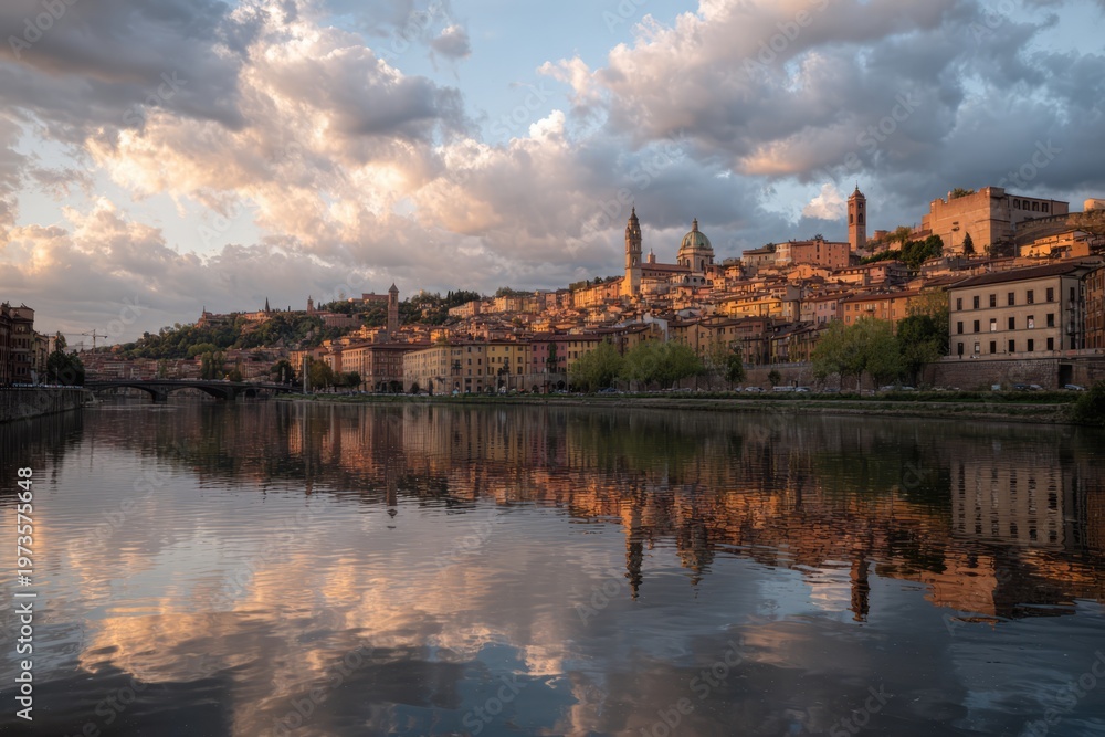 Obraz premium Florence cityscape with Arno River reflection at sunset.