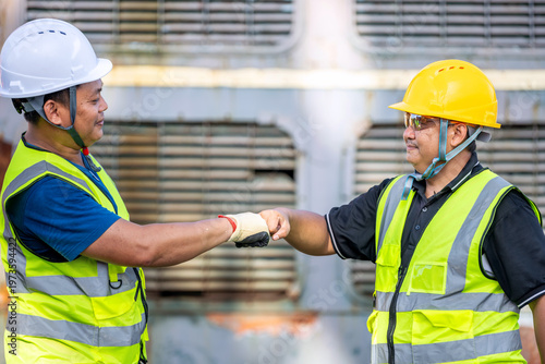 Foto Asian Engineers Fist Bump: Teamwork and Agreement at Railway Construction Site T