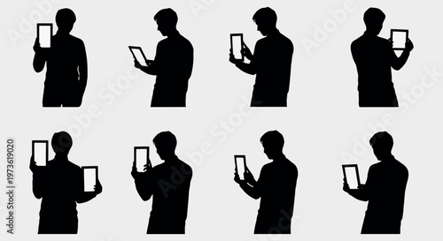 Silhouettes of a person holding and using a digital tablet