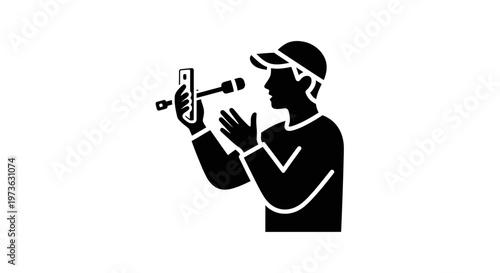 Man in cap recording video on smartphone with external microphone.