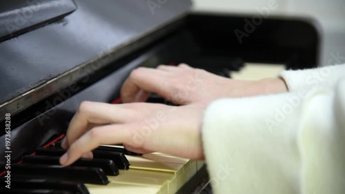 female pianist hands on black and white piano keyboard, close-up view, young woman playing piano, professional musician