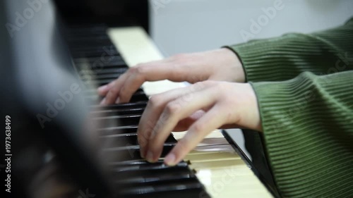 female pianist hands on black and white piano keyboard, close-up view, young woman playing piano, professional musician