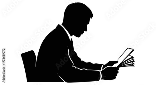 Silhouette of a man reading a book with intense focus.