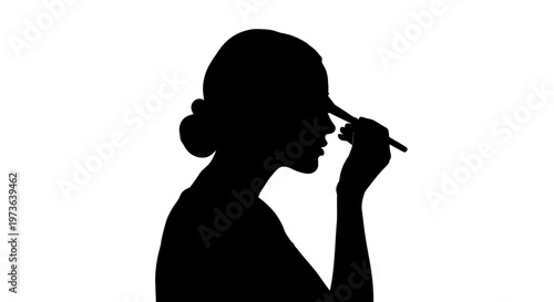 Silhouette of a woman applying makeup with a brush.
