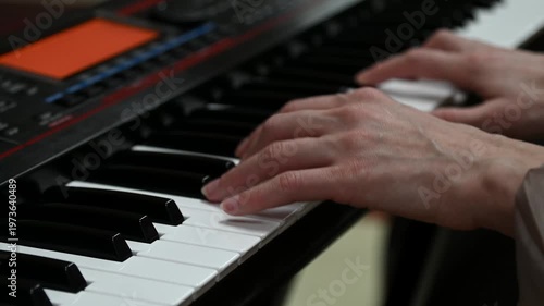 female pianist hands on black and white synthesizer keyboard, close-up view, young woman playing piano, professional musician