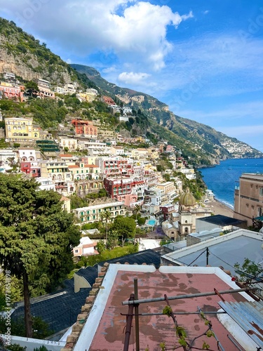 Scenic view of Positano on the Amalfi Coast with colorful cliffside houses, church dome, and turquoise sea, capturing iconic Italian coastal beauty and relaxed summer atmosphere.