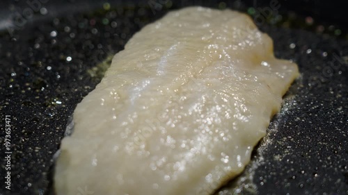 Frying white fish fillets. Frying hake fillets in a hot pan Opaque cod fillet turning tender in pan, gentle simmering, flesh loosening into flakes, soft sheen and subtle browning,