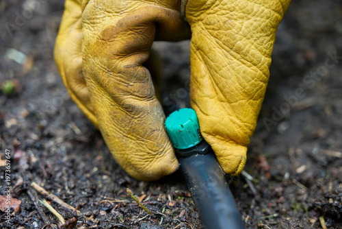 Foto Close up detail of a hand manually adjusting a drip emitter in a garden irrigati
