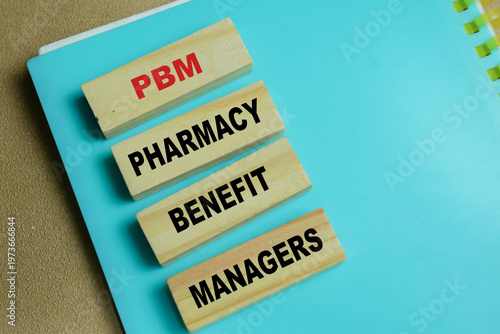 Concept of PBM - Pharmacy Benefit Managers write on book isolated on Wooden Table. For healthcare administration, insurance and drug costs