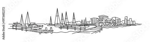 Marina with sailboats moored at docks and waterfront buildings