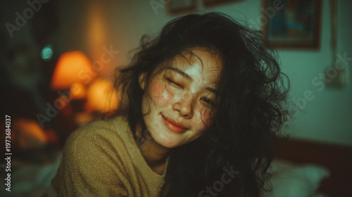 Full-body portrait of a slim adult Korean woman relaxing at home, captured in soft natural light. She smiles gently with eyes closed, expressing quiet happiness and comfort. The scene features a blurr