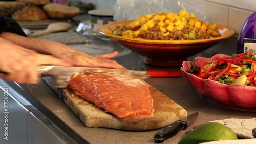 Stockholm, Sweden A cook prepares a side of salmon in a domestic kitchen for a dinner party.