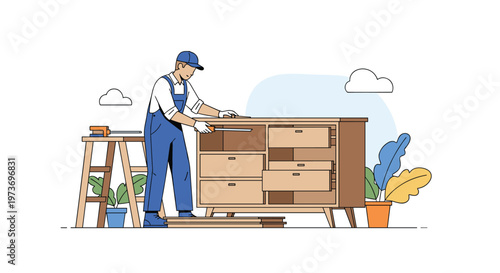 Skilled male carpenter wearing blue overalls and a cap, while assembling a modern wooden cabinet with drawers in his workshop.