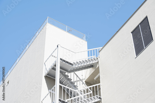 ミニマルなデザインの白い建物と非常階段