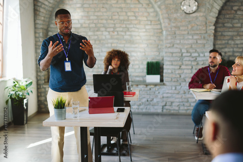 Foto Black businessman facilitating meeting and discussing ideas with diverse team