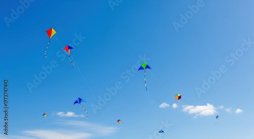 Colorful kites flying in clear blue sky.