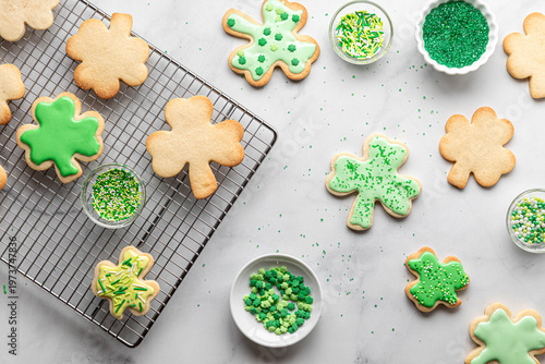 Assorted shamrock sugar cookies with sprinkles for decorating.