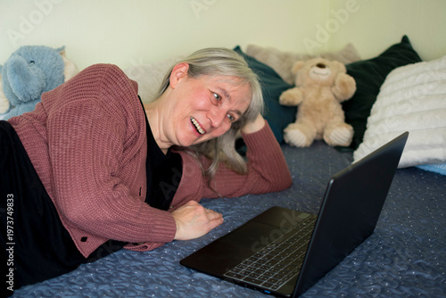 Mature woman smiling while watching laptop during video call
