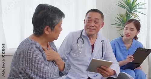Smiling senior doctor discusses health plans using a digital tablet in a modern clinic, focusing on compassionate elder care, patient engagement, and positive medical outcomes.