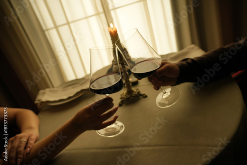 Fotografie Romantic Candlelight Dinner with Red Wine Toast, Warm Low Light Ambience and Soft Focus Atmosphere