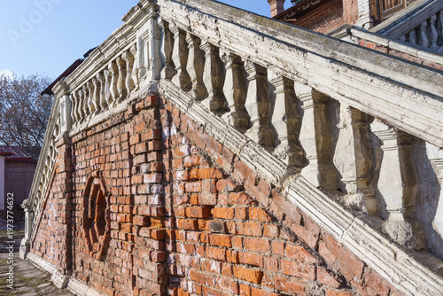 Krutitsy Metochion in Moscow, Russia. Historical brick staircase with ornate balustrade leading to an elevated platform in a well-preserved architectural setting