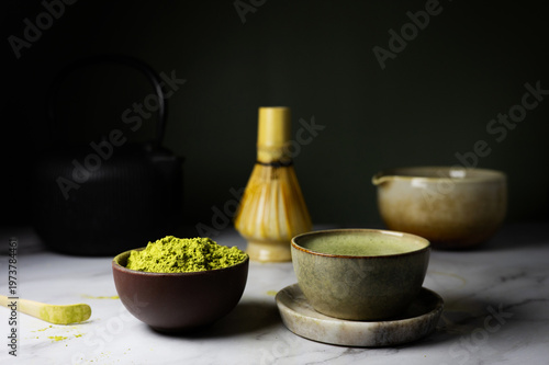 Traditional matcha set with powder, whisk and bamboo spoon.