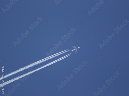 Airplane at high altitude leaving contrails behind.