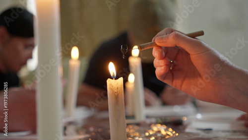 Artisan hands creating a handmade Pysanka for Orthodox Easter celebration, close-up of wax-resist dyeing technique on white egg shell.