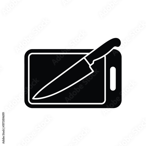 A sharp kitchen knife lies on a cutting board indoors.