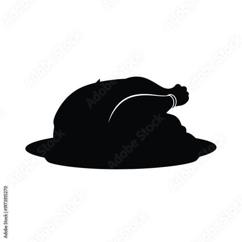 A roasted turkey lies on a plate, served with a tied leg, ready for a holiday meal.