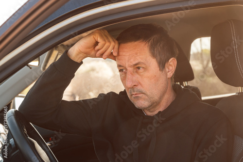 Canvas Print Closeup of mature adult male driver sitting in car and waiting for road assistan
