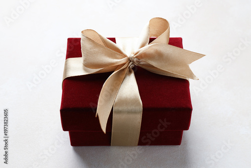 Red gift box with bow on white table, closeup